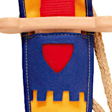 Nahaufnahme der oberen Partie einer bunten Spielzeug-Schwertscheide mit blauer Umrandung, rotem Schildsymbol und gelbem Zinnenmuster. Darüber eine helle Holzparierstange mit rotem Griffband.