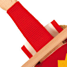 Nahaufnahme eines Holzgriffs mit fest umwickeltem roten Band, darunter ein weiß-rotes Stoffdetail und eine helle Holzparierstange.