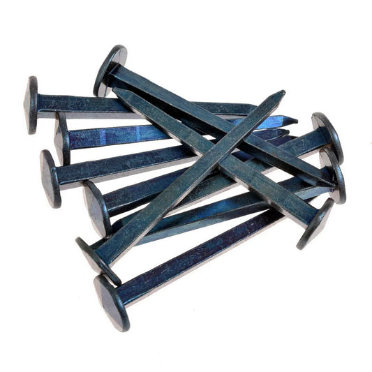 Zehn handgeschmiedete Nägel mit vierschlägigem Kopf auf weißem Hintergrund.