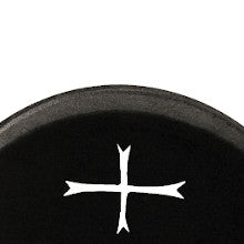 Nahaufnahme des oberen Teils einer Spielzeug-Holzaxt. Die Axtkopf  ist schwarz es ist ein ausgeschnittenes stilisiertes Kreuz mit pfeilförmigen Enden auf dem Axtkopf. Nur der obere, abgerundete Bereich der Axtkopf  ist sichtbar.
